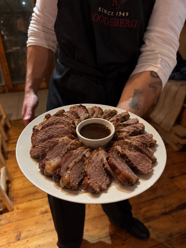 Sliced rump cap arranged around a bowl of jus